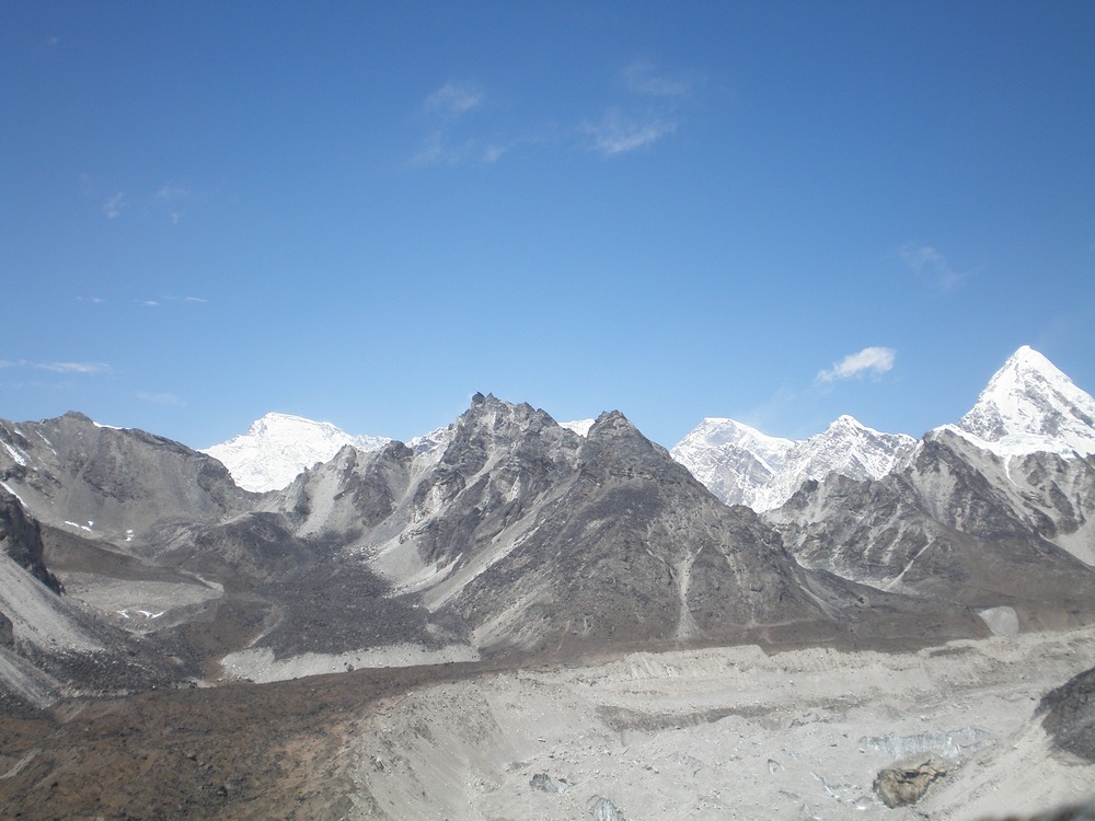 Slikao sam Cho oyu (8201m) - onaj zaobljeni i zaravnjeni vrh levo. Tamo sam bio dve godine pre. Desno je Pumo Ri (7165). Kasnije sam ga gledao i sa severa kada smo peli Everest sa Tibeta. Tuda ide granica sa Kinom, preko tih vrhova. Svaki taj vrh je pola/pola, kineski i nepalski. Kako je široka Cho oya; neobično za planinske vrhove, koji su svi šiljati, i što su višlji to su oštriji.