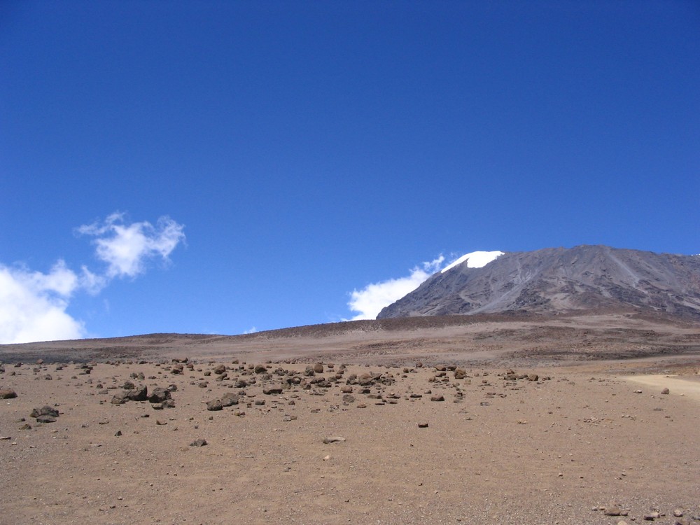 To je Kilimanjaro: malo snega, pustinja, mesečeva površina. Vulkanska lava, pepeo, šljaka. Nema drveta. Nema lepote reljefa. Okolo prazan prostor, samo nebo. U dolini je izmaglica i sa ove visine se ne vidi ništa. Na Andima imaš bar udaljene vidike; Dok  penješ Akonkagvu gledaš Topungato; ceo venac planina pod snegom. Na Himalajima još i više, još i lepše. Kilimanjaro je monoton. Lepo utaban put, 2m širok, sa propustima za vodu, da ga bujica ne odnese.